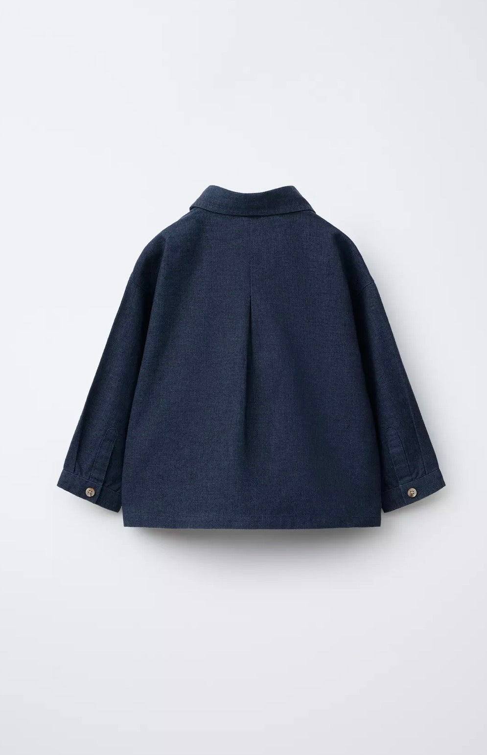 Back view of navy linen kids' shirt showing center pleat, buttoned cuffs, and clean collar construction
